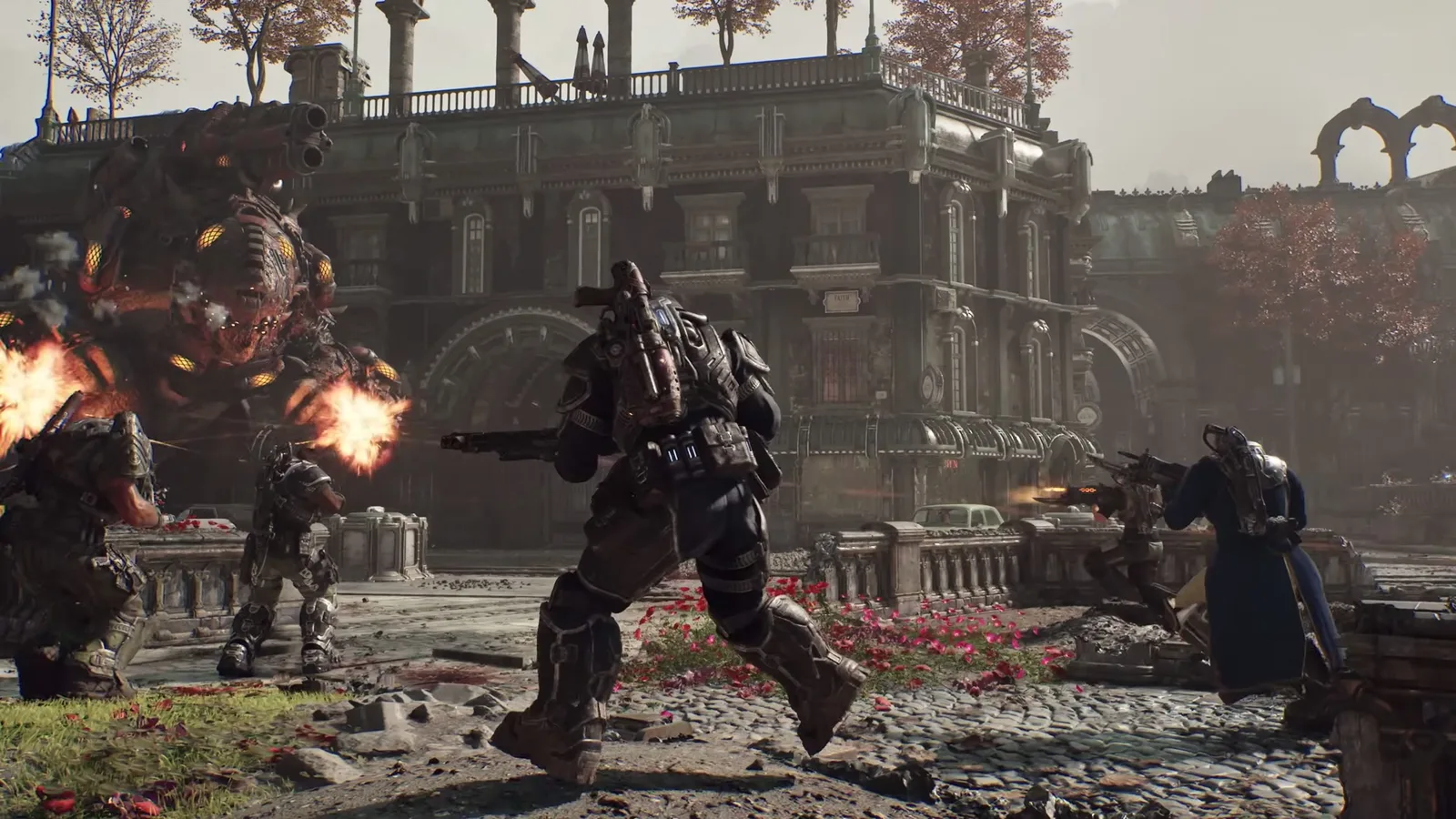 Tres soldados COG disparan a una enorme máquina de guerra Locust de ojos amarillos frente a un edificio en ruinas en Gears of War: E-Day