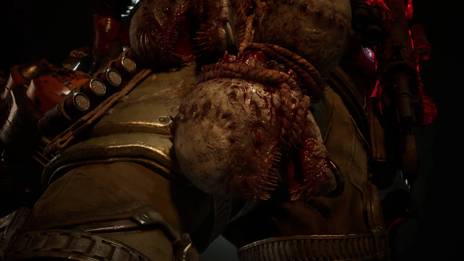Un enorme enemigo Locust cargado de cabezas y munición se alza en la oscuridad frente a Tai en Gears of War: E-Day