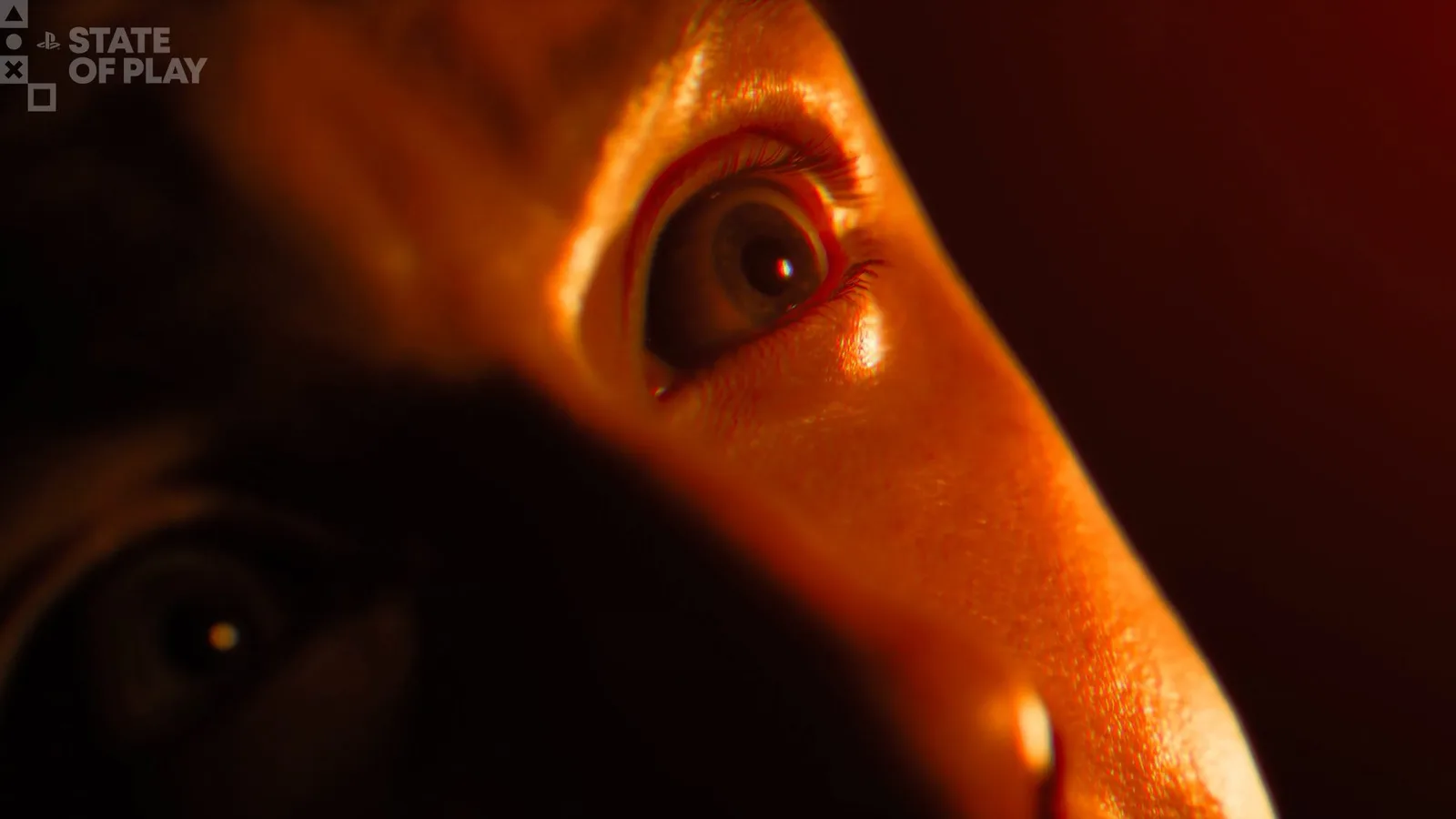 Primer plano de un ojo iluminado por luz roja, tomado del tráiler de revelación de Until Dawn 2 en el State of Play